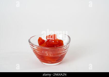 Confiture de coings maison dans un petit bol en verre isolé sur fond blanc. Banque D'Images