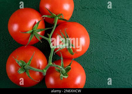 Un groupe de tomates raisins sur fond vert, vue du dessus Banque D'Images