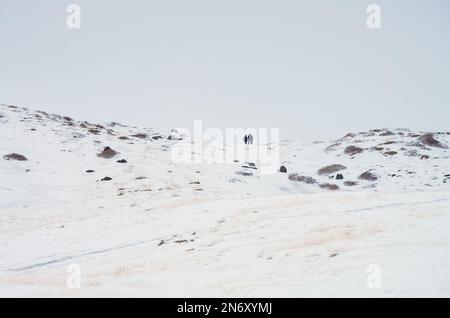 Photographie minimaliste d'un paysage enneigé de montagne avec silhouette de personnes au bord de la « Valle del Bove » le long du chemin sur la « chiena » Banque D'Images