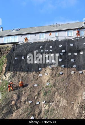 Travaux de stabilisation des falaises au parking de Quarry Lane à Falmouth, en Cornouailles, en Angleterre. Les travailleurs en descente effectuent un travail essentiel. Banque D'Images