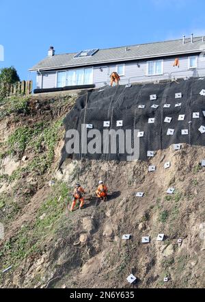 Travaux de stabilisation des falaises au parking de Quarry Lane à Falmouth, en Cornouailles, en Angleterre. Les travailleurs en descente effectuent un travail essentiel. Banque D'Images