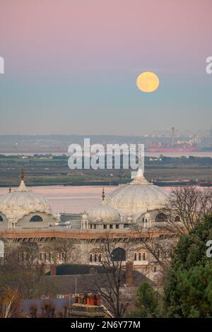 Pleine lune s'élevant au-dessus du DP World London Gateway Port avec le Siri Guru Nanak Darbar Gurdwara à Gravesend de la colline du moulin à vent. Banque D'Images