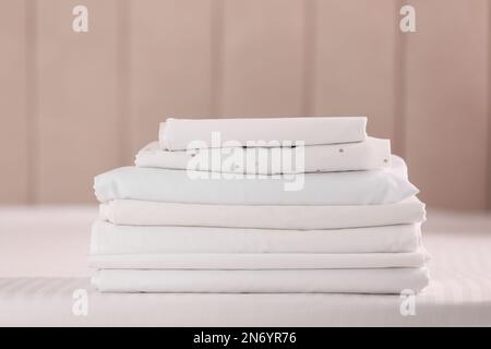 Pile de draps propres pliés sur le lit à l'intérieur Banque D'Images