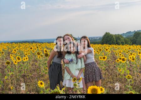 Les adolescentes s'amusent dans un champ de tournesol en fin d'après-midi d'été. Copier l'espace. Banque D'Images