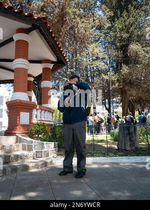 La Paz, Bolivie - 1 octobre 2022: Cameraman enregistrement sur la rue tandis qu'un grand nombre de personnes sont dans le fond Banque D'Images