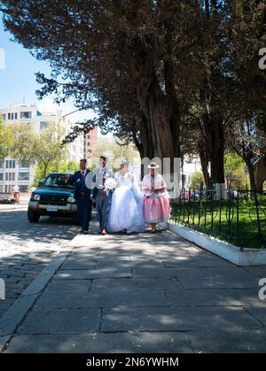 La Paz, Bolivie - 1 octobre 2022 : couple nouvellement mariés avec leurs parents marchant sur la place dans le quartier de Sopocachi Banque D'Images