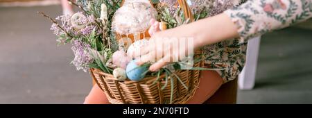 joyeuses fêtes de pâques au printemps. petite fille de huit ans tient le panier avec des œufs peints et des gâteaux de pâques cuits. décoration de fête. Banque D'Images