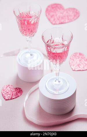 Couple tenant deux cocktails roses pour la Saint-Valentin. L'amour et le cadre d'anniversaire avec les coeurs. Concept romantique Banque D'Images
