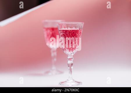 Couple tenant deux cocktails roses pour la Saint-Valentin. L'amour et le cadre d'anniversaire avec les coeurs. Concept romantique Banque D'Images