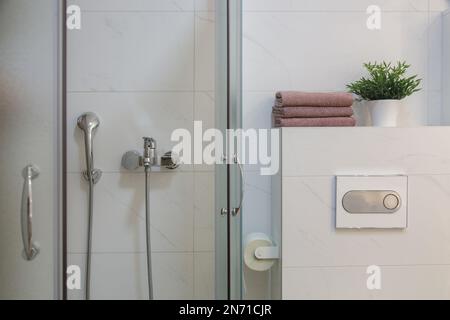 Intérieur de la salle de bains avec carrelage blanc en céramique sur les murs et cabine de douche en verre Banque D'Images