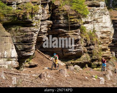 E-motard de montagne sur un seul sentier dans le Mullerthal. Chemin rocailleux étroit sur la pente raide le long de la vallée de Sauer en direction de Berdorf. Pour de bons motards facile à monter, pour les débutants Border, parce que étroit, partiellement exposé et jonché de pierres et de rochers. Ci-dessous coule la frontière de la Sauer, de l'autre côté est la partie allemande du Müllertal. Banque D'Images