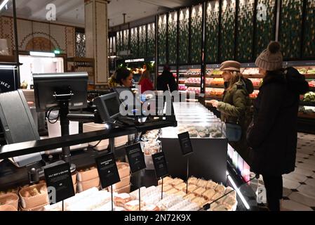 Les halls de restauration Harrods servent des délices culinaires du monde entier préparés tous les jours. Les plats que vous voyez dans le Fresh Market Hall sont tous faits sur place par l'équipe de 150 chefs. Sous la direction du chef cuisinier Andy Cook et du chef chef principal Andy Ward (dont la carrière a inclus des conseils de Gordon Ramsey et Marcus Waering, respectivement), les cuisines sur place envoient tout, des meilleurs petits pains à saucisse au bœuf Wellington, tous faits avec des ingrédients des Food Halls. Banque D'Images