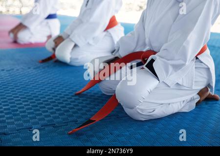 Enfants dans les kimonos assis sur le terrain d'entraînement, en gros plan Banque D'Images