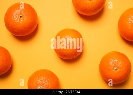 Mandarines mûres fraîches sur fond jaune, couché à plat Banque D'Images