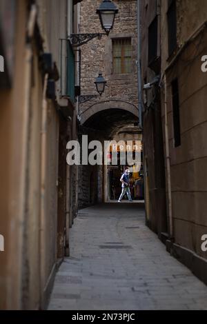 Homme marchant dans une rue étroite dans le quartier gothique. Barcelone, Espagne Banque D'Images