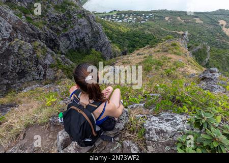 Une jeune femme sportive assise au sommet de la célèbre montagne mauricienne le Morne Brabant. Banque D'Images