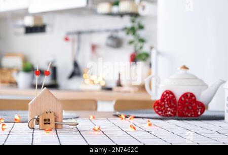 La clé de la maison de la maison confortable avec la décoration de Saint-Valentin sur la table de la cuisine. Cadeau pour la Saint Valentin, nid d'amour familial. Construction, conception, projet, déménagement à ne Banque D'Images