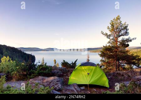 Tente dans le désert suédois avec vue panoramique sur le lac, les montagnes et la forêt Banque D'Images