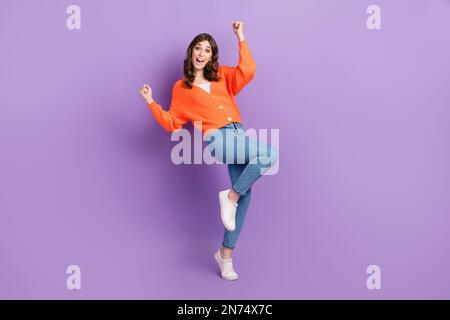 Photo de la taille du corps de la jeune femme optimiste excitée Fists up porter ensemble élégant célébrer la victoire isolé sur fond violet Banque D'Images