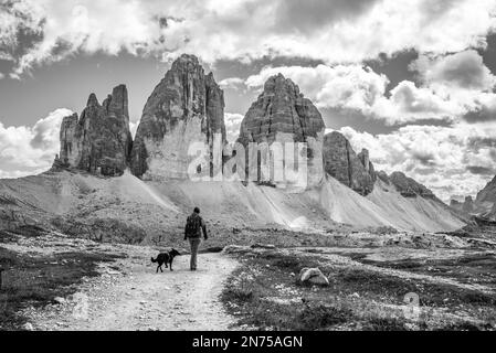 Une femme randonnée solitaire avec son chien autour des montagnes de Drei Zinnen, les Dolomites dans le Tyrol du Sud Banque D'Images