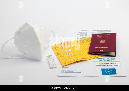 FFP2 masque, cassette de test d'antigène Rapid SARS-CoV-2 avec résultat de test négatif, certificat COVID numérique de l'UE, carte de vaccination avec enregistrement des dernières vaccinations Corona, Passeport de la République fédérale d'Allemagne, fond blanc, Banque D'Images