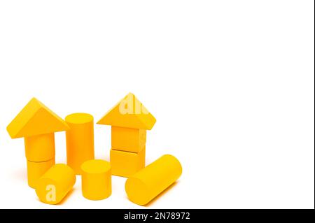 figures jaunes faites de briques de formes différentes sur fond blanc. un constructeur pour le développement des enfants. maquette Banque D'Images