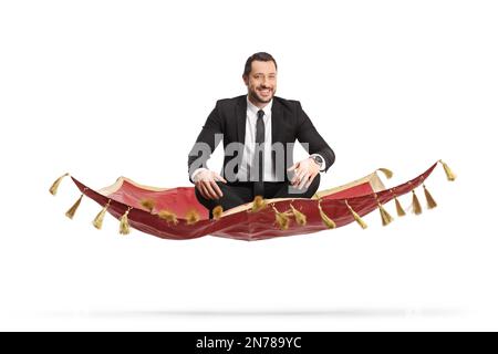 Jeune homme professionnel en costume et cravate volant sur un tapis rouge isolé sur fond blanc Banque D'Images