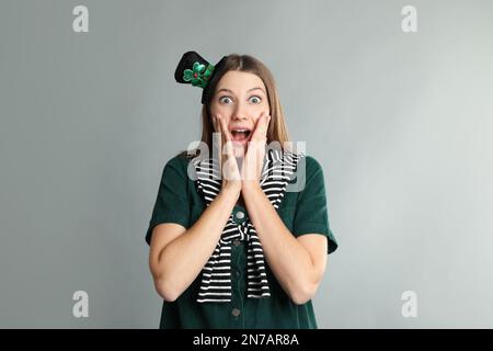 Femme émotive en tenue de St Patrick sur fond gris clair Banque D'Images