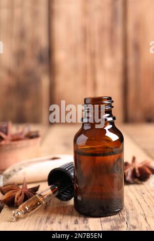 Bouteille d'huile essentielle, compte-gouttes et anis sur table en bois Banque D'Images