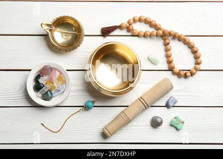 Composition de plat avec bol à chant doré sur table en bois blanc. Rétablissement du son Banque D'Images