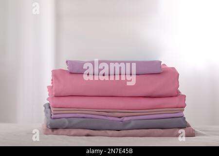 Pile de draps pliés de couleur propre sur le lit Banque D'Images
