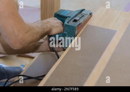 Pendant la construction menuisier travaille avec la nouvelle maison meulant escalier en bois Banque D'Images