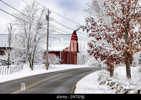 Une ancienne grange rouge recouverte de neige à Royalston, Massachusetts Banque D'Images