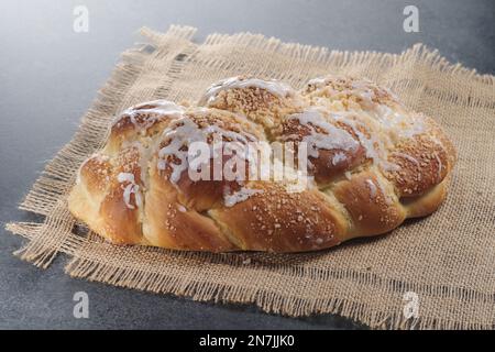 Challah fraîchement cuit sur une nappe beige. Habituellement tressé et typiquement mangé à des occasions cérémonielles telles que Shabbat et les grandes fêtes juives Banque D'Images