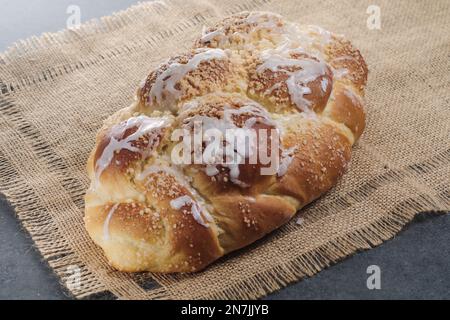 Challah fraîchement cuit sur une nappe beige. Habituellement tressé et typiquement mangé à des occasions cérémonielles telles que Shabbat et les grandes fêtes juives Banque D'Images