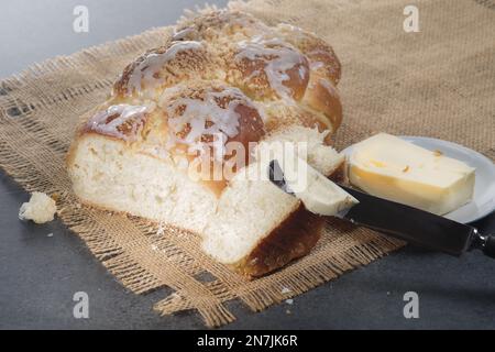 Challah fraîchement cuit sur une nappe beige. Habituellement tressé et typiquement mangé à des occasions cérémonielles telles que Shabbat et les grandes fêtes juives Banque D'Images