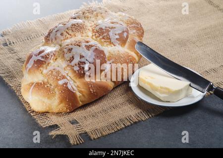 Challah fraîchement cuit sur une nappe beige. Habituellement tressé et typiquement mangé à des occasions cérémonielles telles que Shabbat et les grandes fêtes juives Banque D'Images