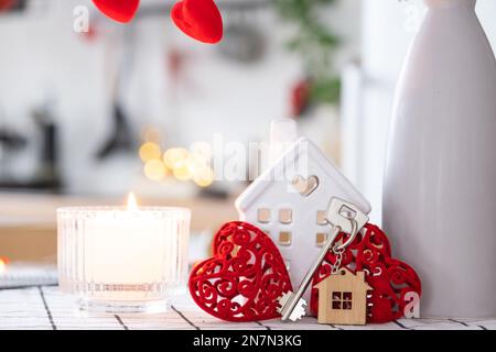 La clé de la maison de la maison confortable avec la décoration de Saint-Valentin sur la table de la cuisine. Cadeau pour la Saint Valentin, nid d'amour familial. Construction, conception, projet, déménagement à ne Banque D'Images