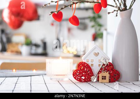 La clé de la maison de la maison confortable avec la décoration de Saint-Valentin sur la table de la cuisine. Cadeau pour la Saint Valentin, nid d'amour familial. Construction, conception, projet, déménagement à ne Banque D'Images