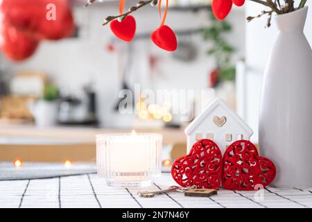 La clé de la maison de la maison confortable avec la décoration de Saint-Valentin sur la table de la cuisine. Cadeau pour la Saint Valentin, nid d'amour familial. Construction, conception, projet, déménagement à ne Banque D'Images