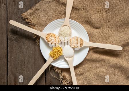 riz au sucre pois pâtes céréales sur des cuillères en bois sur la table de la cuisine, nourriture Banque D'Images