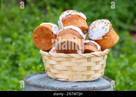 Gâteau de Pâques dans un panier de paille sur une table à l'extérieur gros plan, vacances de Pâques Banque D'Images