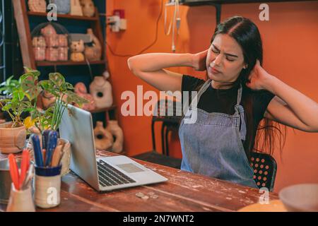 artiste pot handcraft vendeur d'affaires propriétaire fatigué stress de travail dur pendant la nuit. femme douleur musculaire Banque D'Images