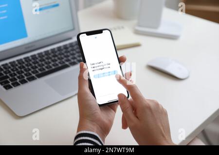 MYKOLAIV, UKRAINE - 28 AOÛT 2020: Femme tenant l'iPhone 11 avec l'application Twitter à l'écran à la table, gros plan Banque D'Images