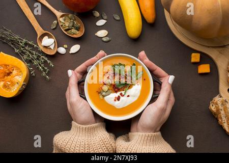 flat lay bol à soupe de courge d'hiver tenu par les mains Banque D'Images