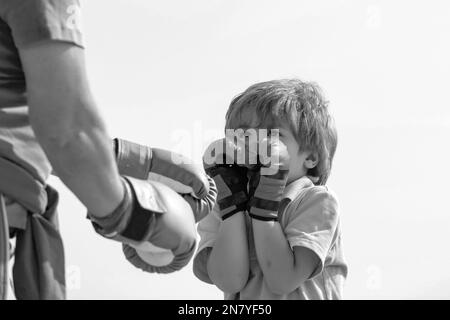 Grand-père et petit-fils combattant en bonne santé avec des gants de boxe. Drôle mignon lutte d'enfant. Drôle d'homme barbu - grand-père avec enfant garçon debout Banque D'Images