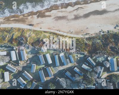 Vue sur les chalets de vacances vus près d'un littoral en hiver. Du givre est visible sur les toits. Banque D'Images