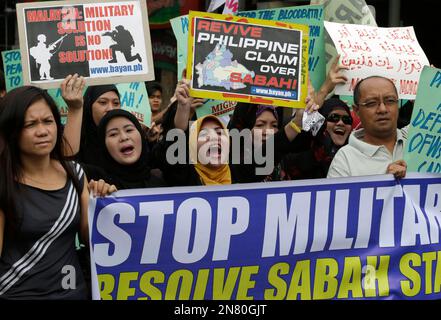 Filipino Muslims are joined by other protesters as they shout slogans ...