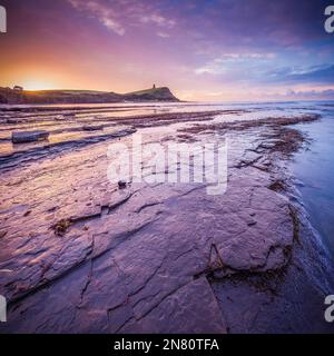Kimmeridge, Royaume-Uni - magnifique lever de soleil coloré avec phare, rochers et marée basse à Kimmeridge Bay, Dorset, Royaume-Uni Banque D'Images