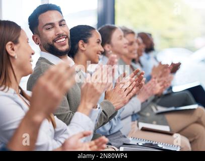 Un groupe diversifié de professionnels souriants se mêlant à la formation de bureau. Une équipe de collègues professionnels qui applaudissent et célèbrent ensemble tout en apprenant Banque D'Images